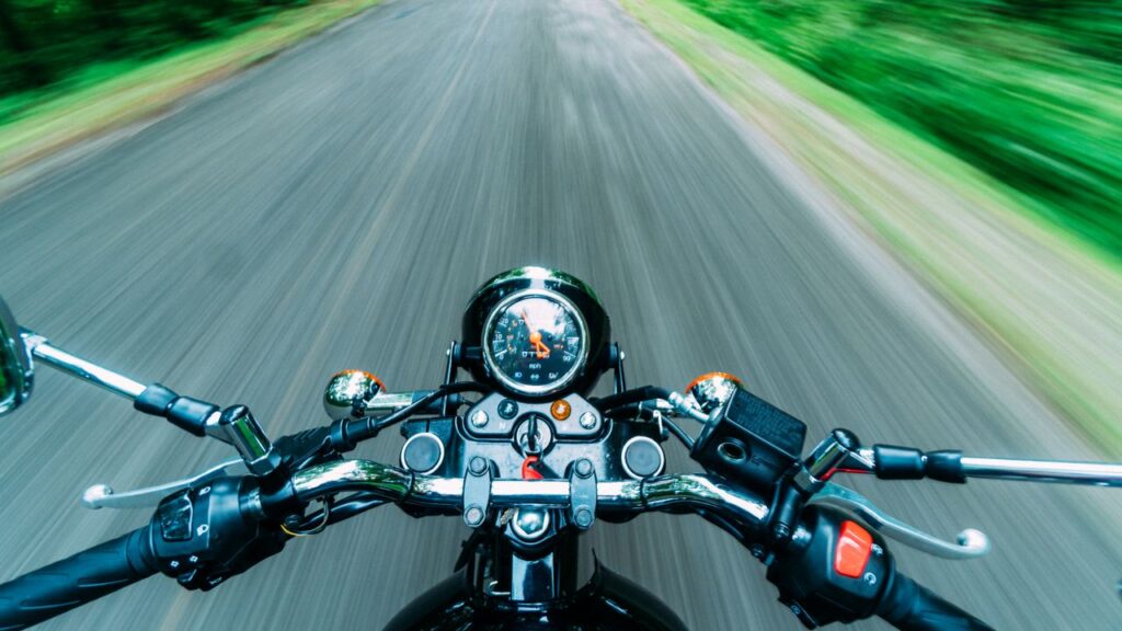 Experience the thrill of a high-speed motorcycle ride through nature's scenic road from a rider's perspective.