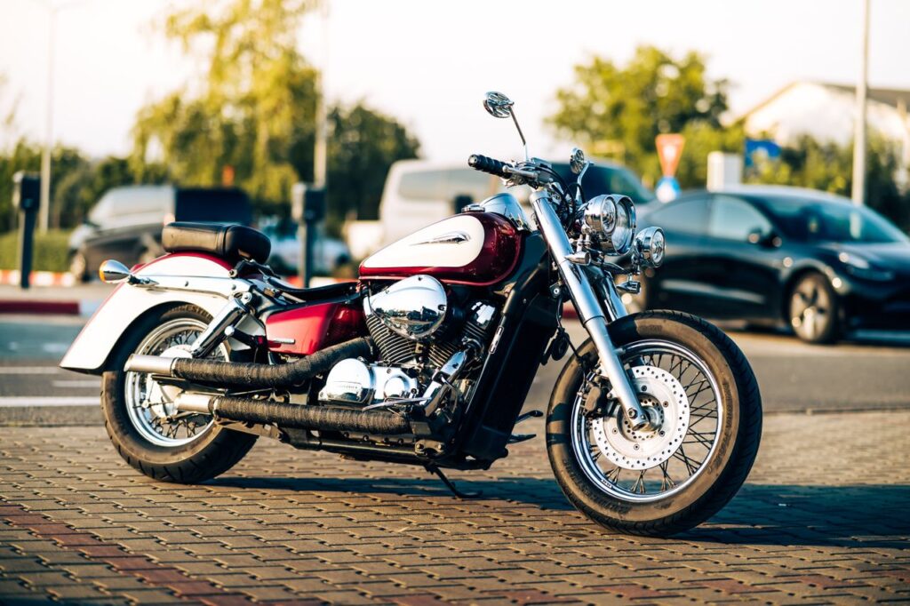 A vintage motorcycle parked on a cobblestone street during sunset, showcasing urban vibes.